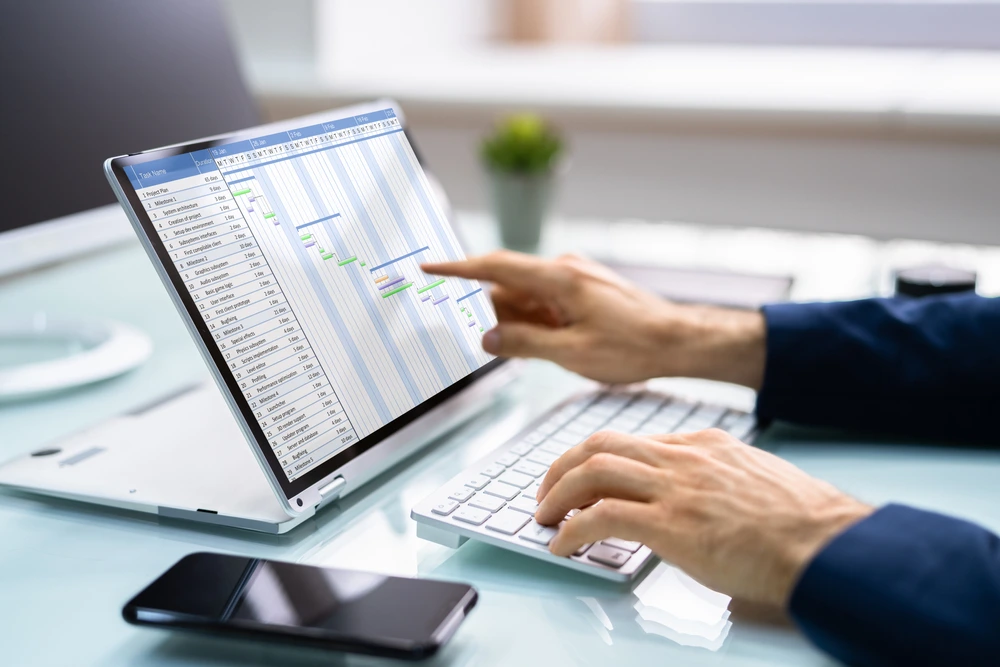 Person using laptop with Gantt chart for organized 2290 form filing online